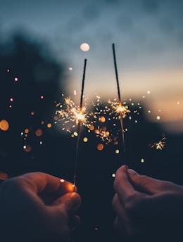 person holding fire cracker shallow focus photography