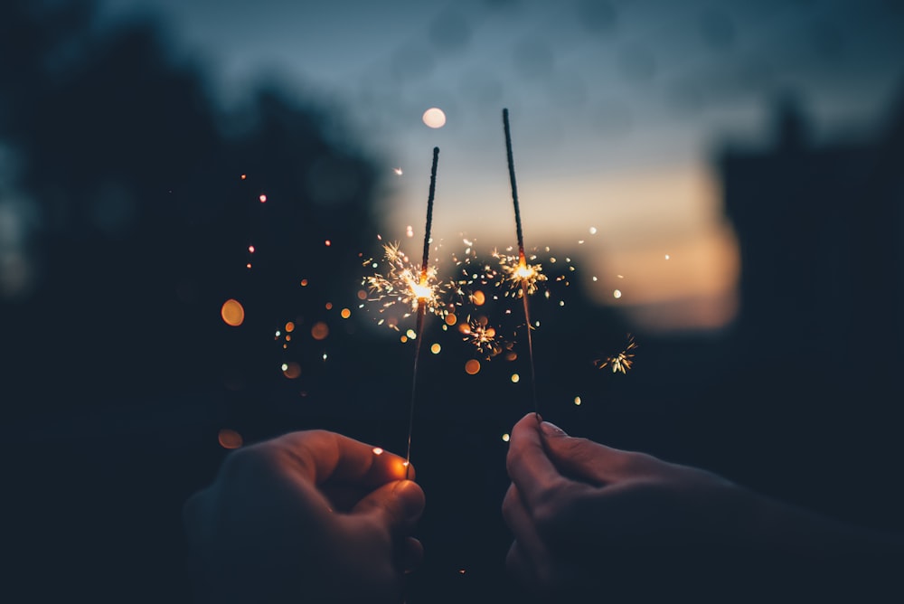 person holding fire cracker shallow focus photography