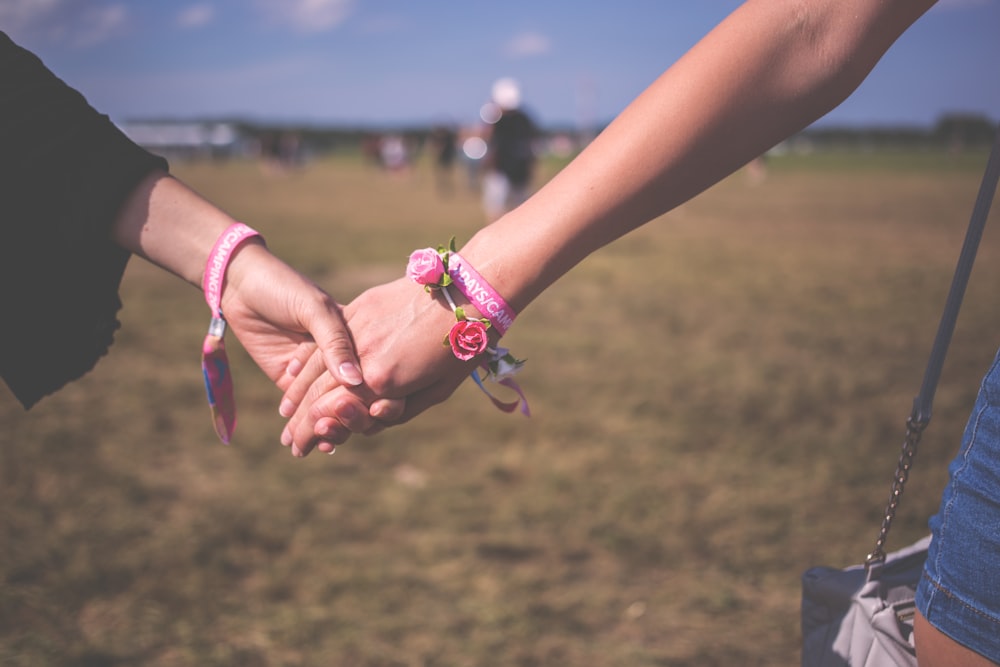 two person holding each other hands