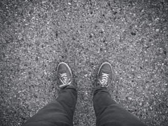 Close-up of feet running on asphalt city street, no brand logos visible.
