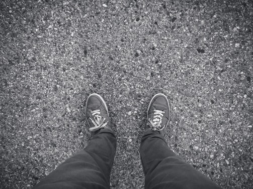 Close-up of feet running on asphalt city street, no brand logos visible.