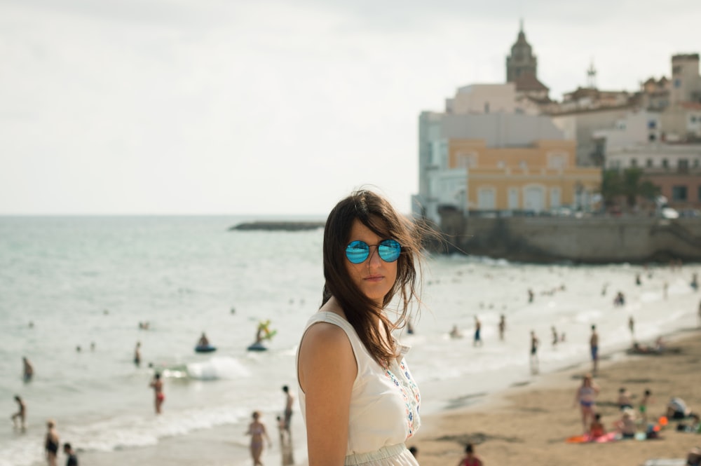 woman in white sleeveless top near seashore