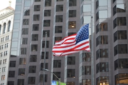 American flag waving outside a government building.