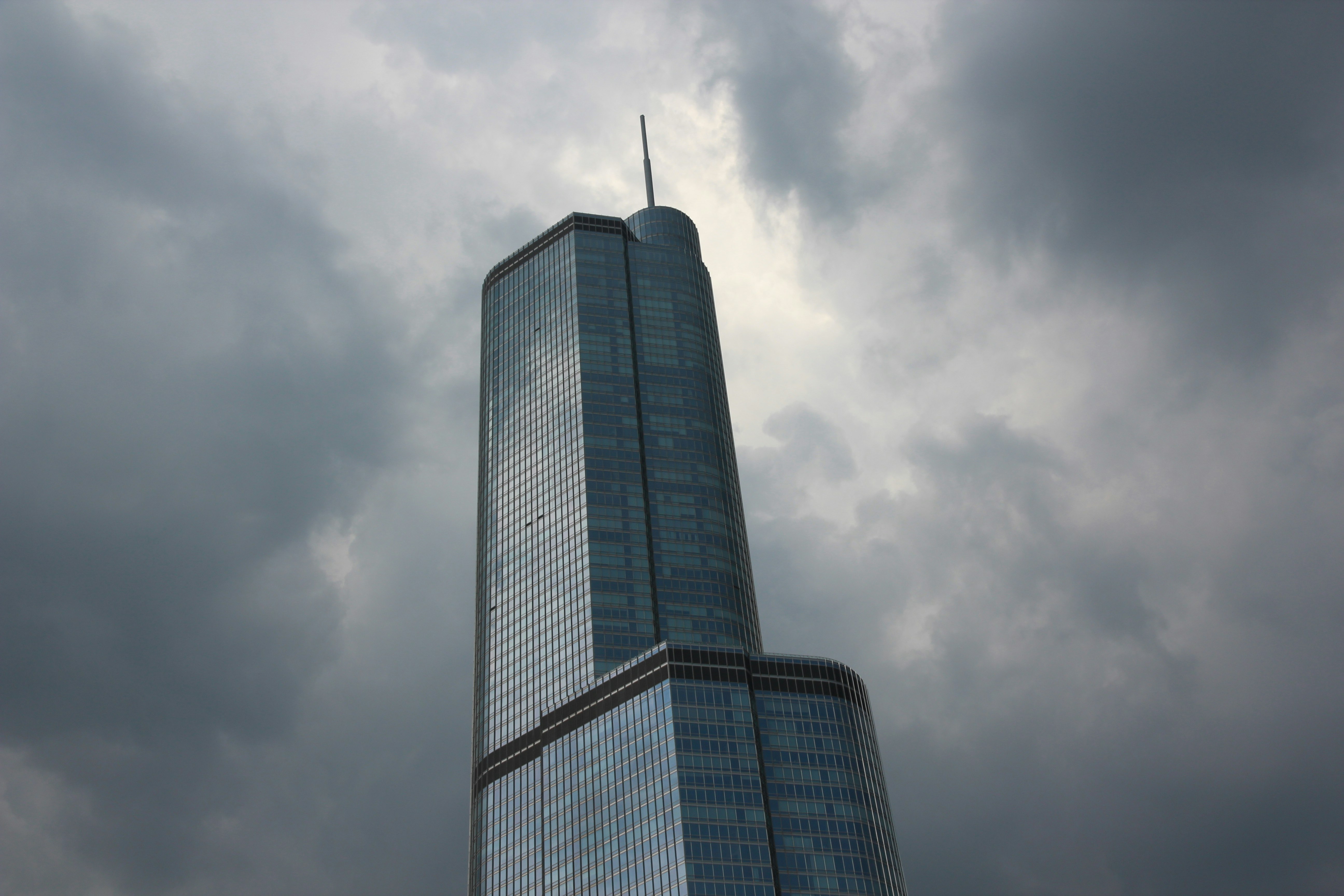 low angle photography of gray high-rise building under cloudy sky