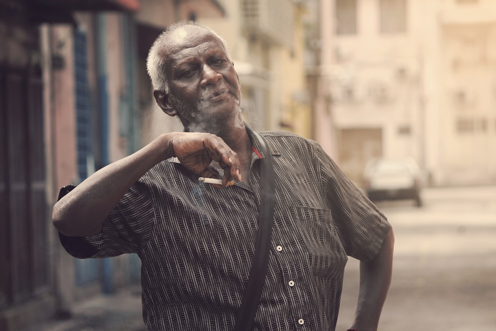 man holding cigarette during daytime