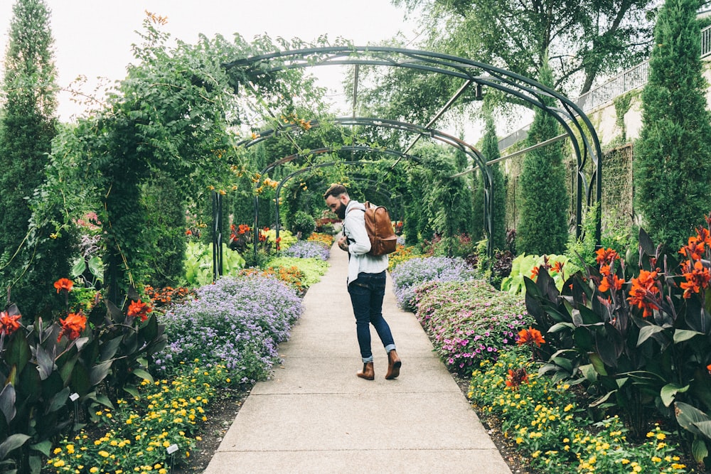 Bearded man walking through Cheekwood-Art & Gardens admiring the colorful flowers and the lush greenery