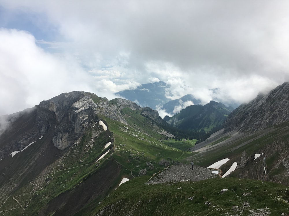 昼間の撮影中の白い空の下の灰色と緑の山