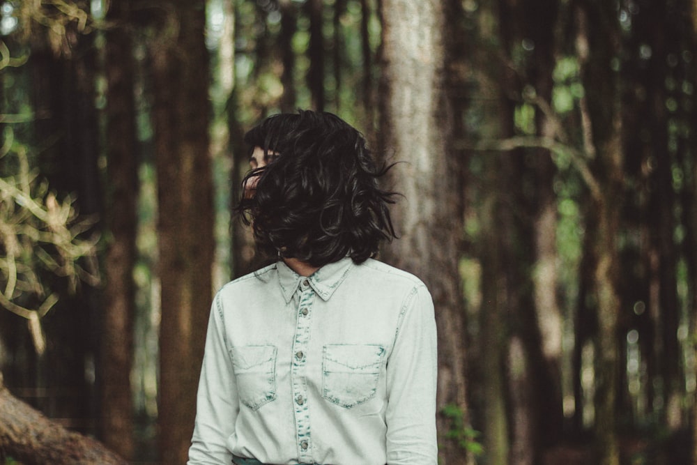 woman in white denim dress shirt taking a photo