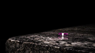 Close-up of the three Aura pills: blue, pink, and obsidian, elegantly arranged on a sleek white surface.