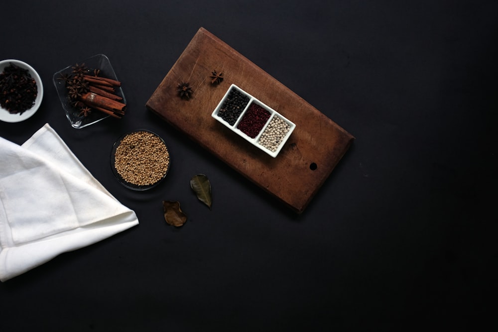 Fotografia plana de feijão em tábua de madeira marrom ao lado de lenço branco