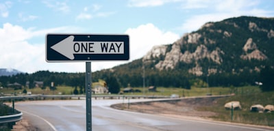 one way street sign beside road far at the mountain during daytime sign google meet background