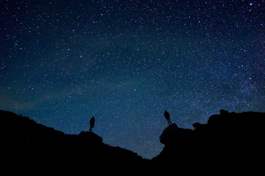 A colorful illustration of two adventurous kids exploring the icy surface of Titan under a starry sky.