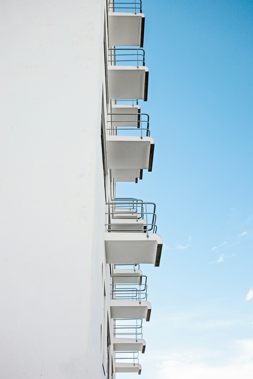 Weißes Betongebäude tagsüber unter blauem Himmel