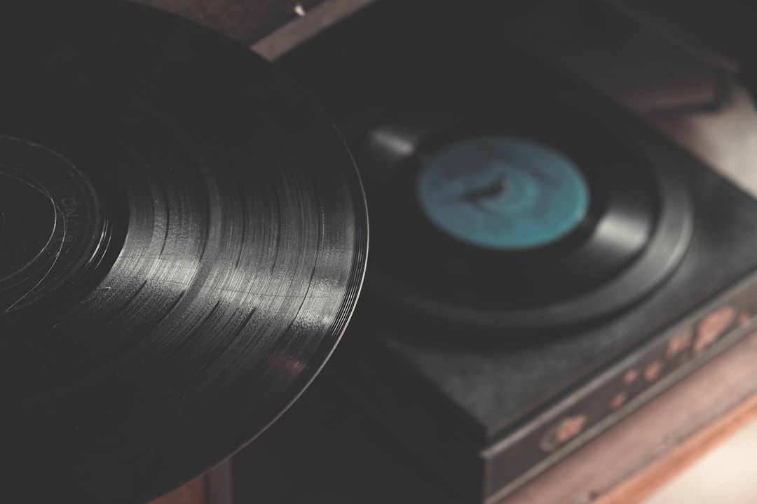 An overhead shot of a vinyl record on a cabinet over a vinyl player