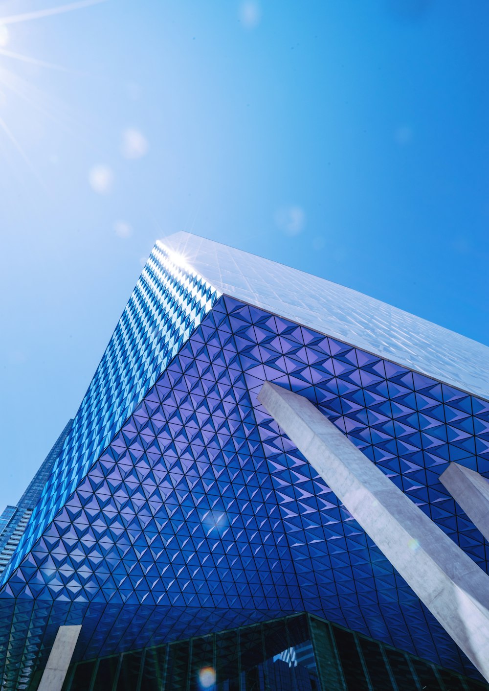 blue glass walled building under blue skies