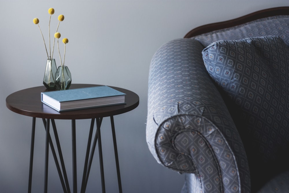 blue book on round brown end table near sofa