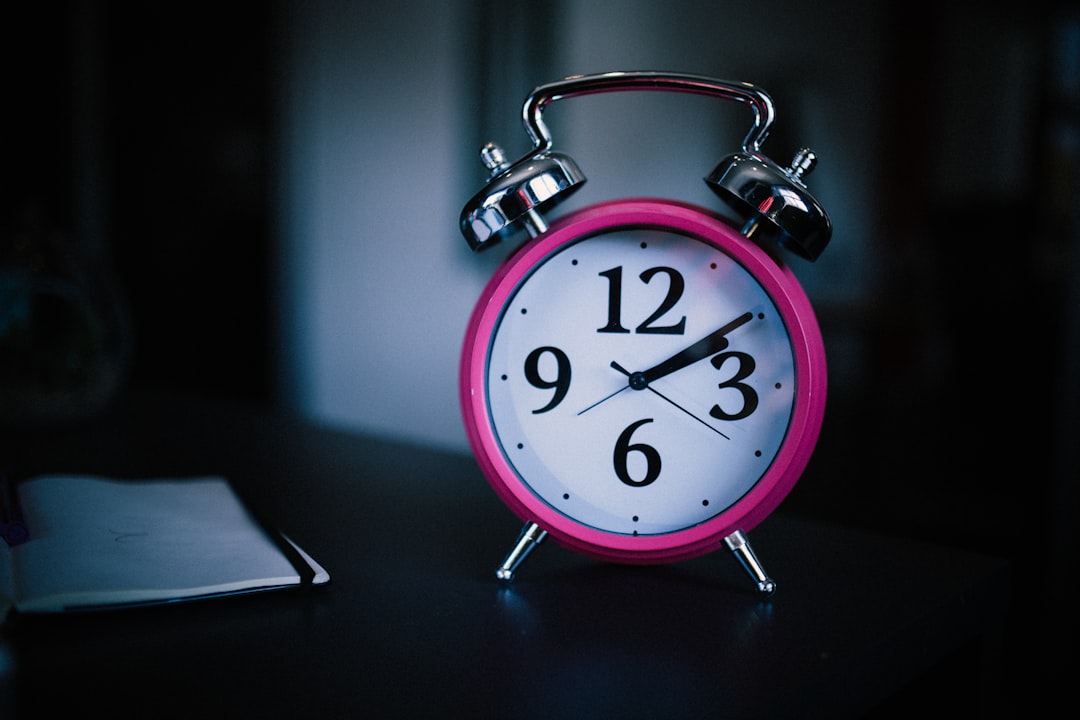 pink alarm clock with white face.