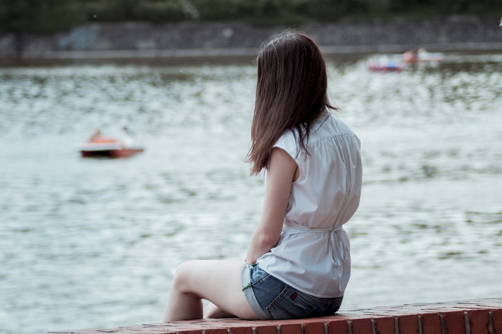 woman sitting on red concrete bench