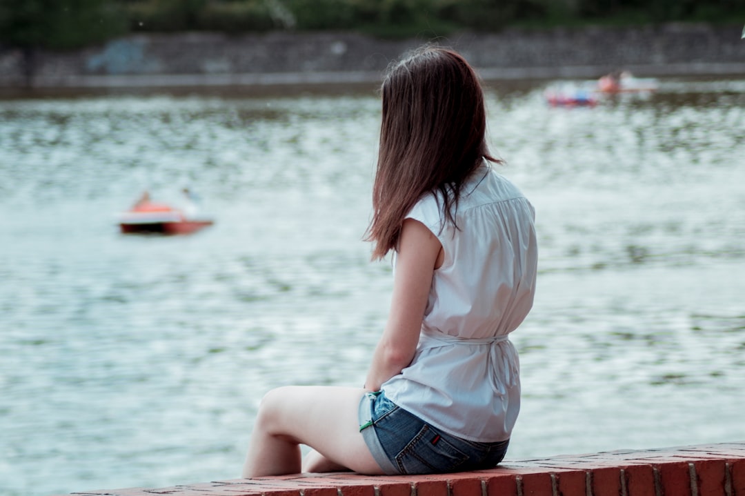 woman sitting on red concrete bench