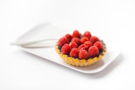 photo of chocolate cupcake with berry toppings on white ceramic plate