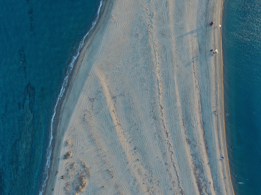 水域に囲まれた白い砂浜の空中写真