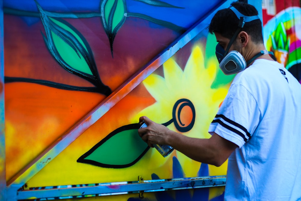 man paint flower on wall