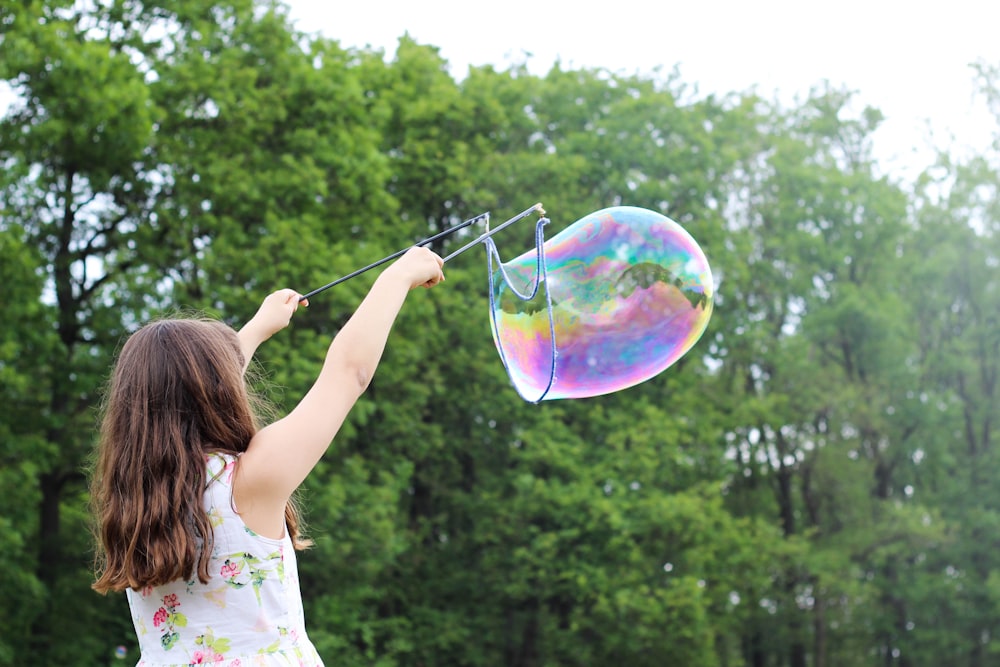 girl making bubbles during daytime