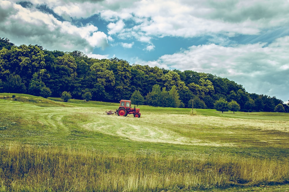 tracteur rouge sur un champ d’herbe verte