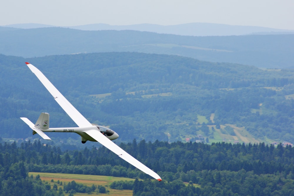 Weißes Flugzeug, das tagsüber in der Luft fliegt