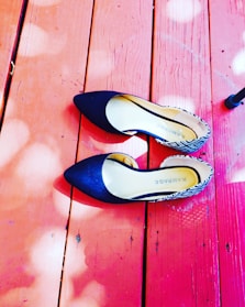 A pair of chic flats on a wooden floor.