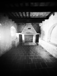 Interior shot showing a vintage fireplace and wooden beams.