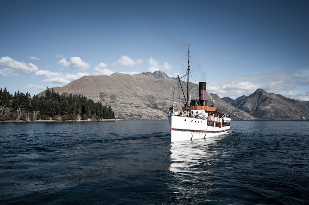 white ship near island of mountain during daytime