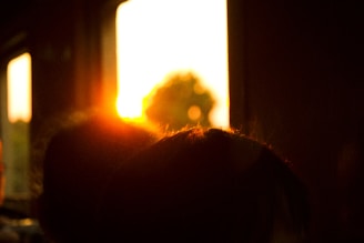 A sunset viewed through a window, casting warm hues over a quiet living room.