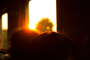 Sunset glowing through a tall, narrow window in a minimalist room.