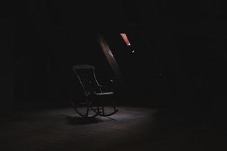 brown wooden rocking chair inside dark room