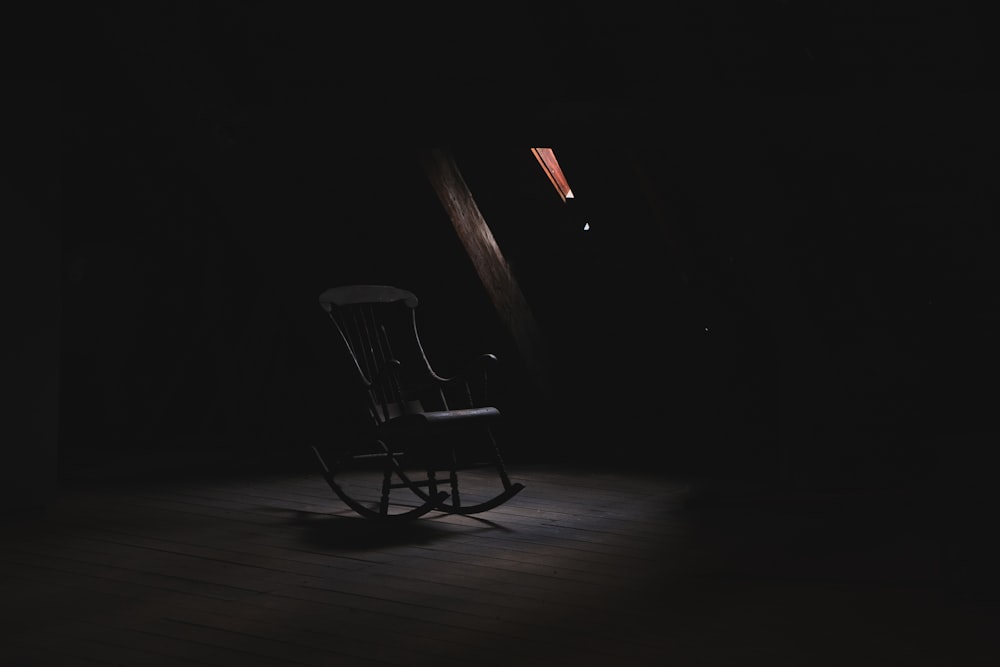 brown wooden rocking chair inside dark room