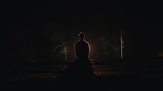 A serene figure meditating under a starry night sky.