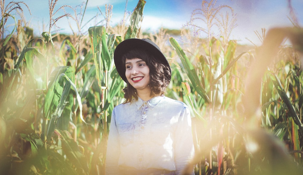 woman in blue denim top standing on cornfield