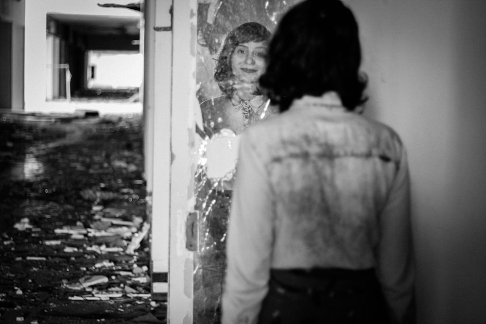 a woman standing in front of a wall with a picture on it