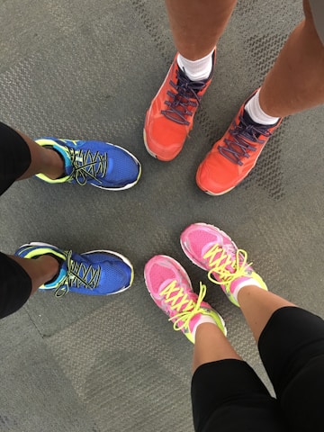 A happy group of diverse people wearing colorful sneakers, smiling together outdoors.