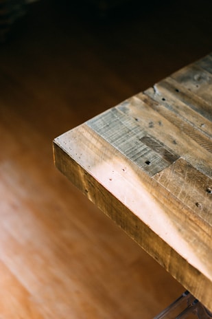 Close-up of a beautifully grained wooden coaster resting on a rustic table.