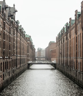 body of water between brown concrete buildings during daytime