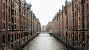 body of water between brown concrete buildings during daytime