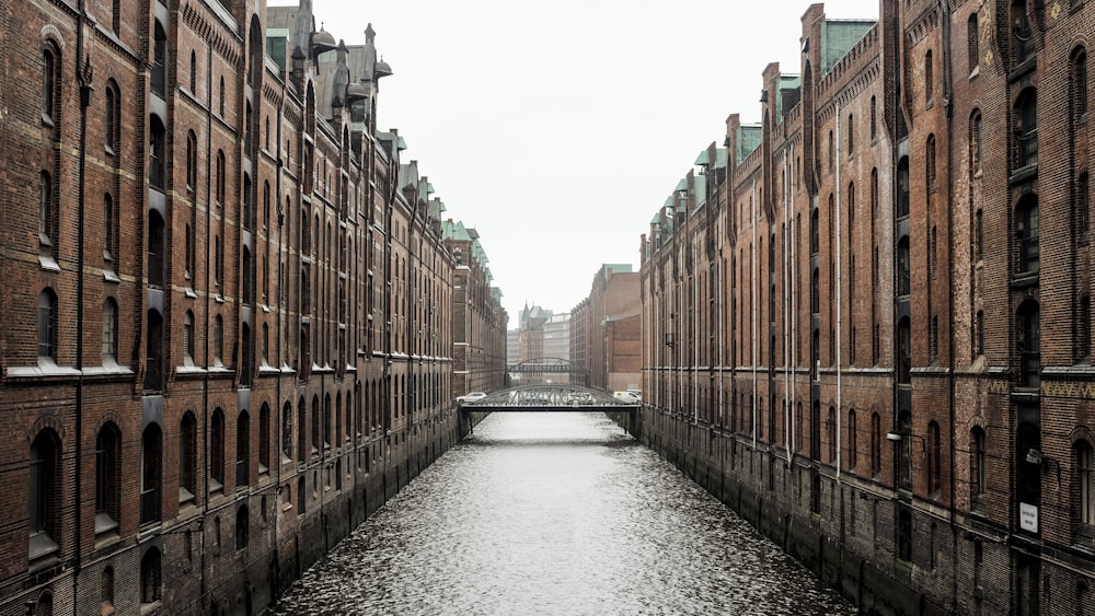 specchio d'acqua tra edifici in cemento marrone durante il giorno