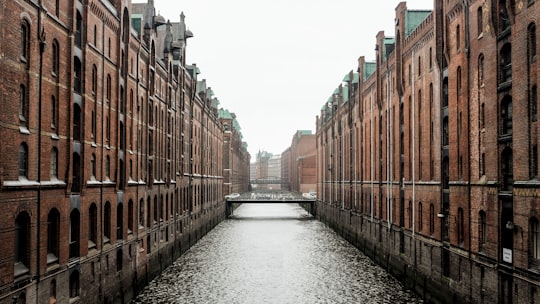 body of water between brown concrete buildings during daytime in Speicherstadt Germany