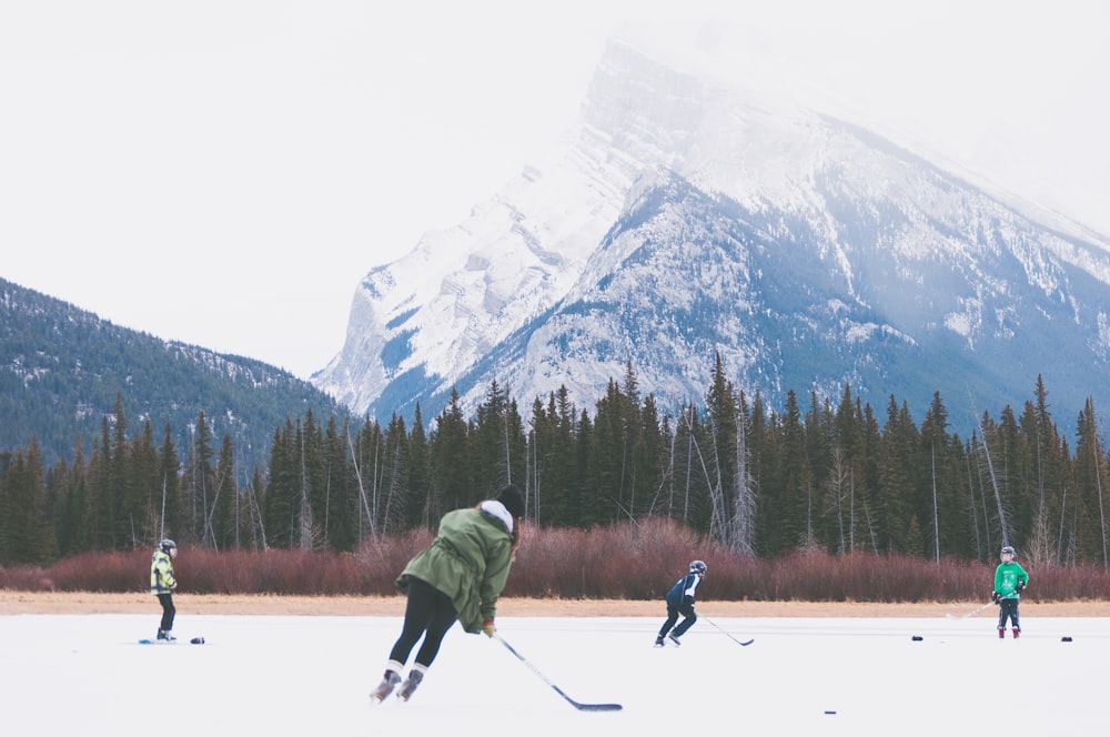 people playing hockey on icefield at datyime