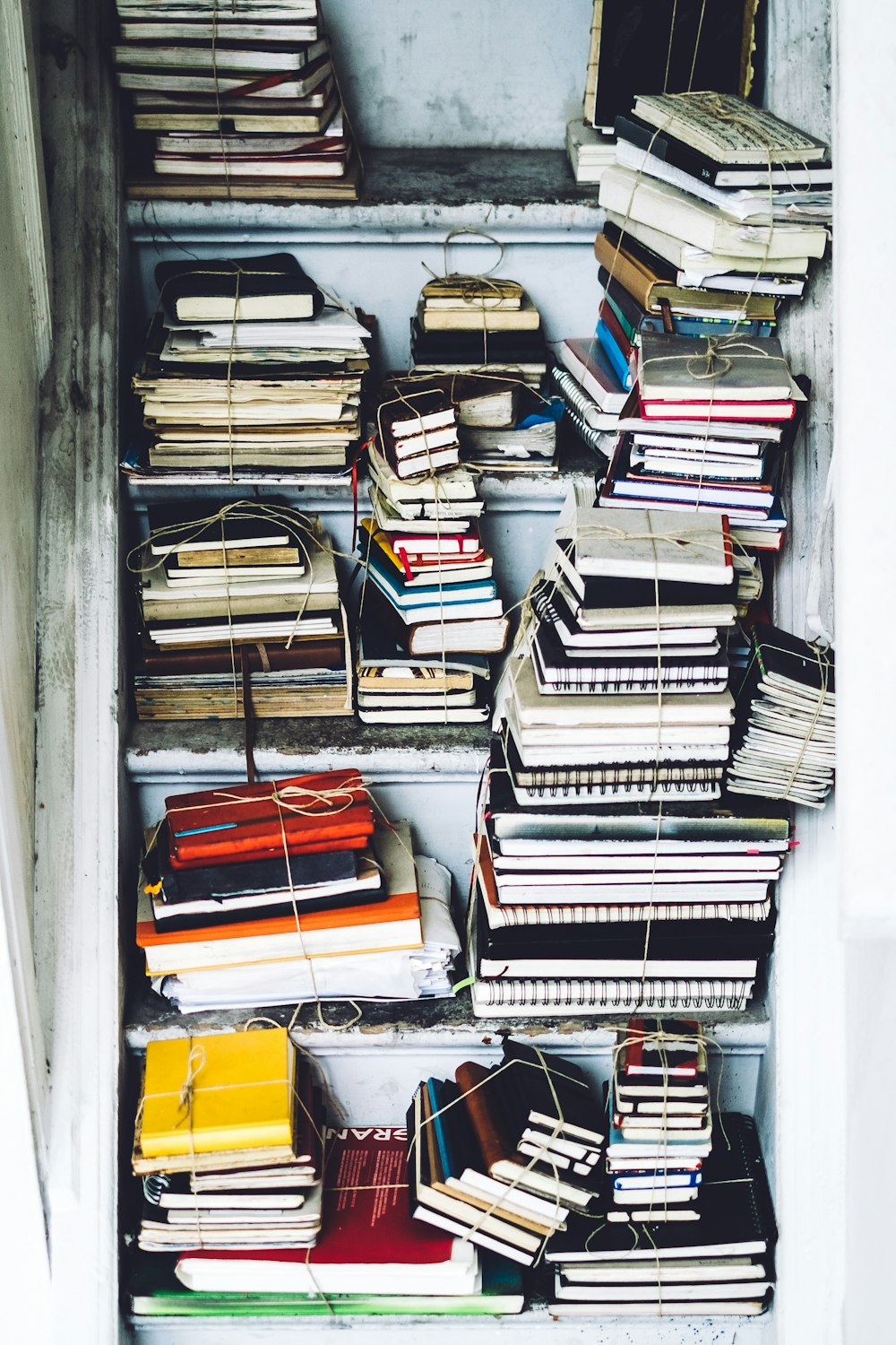 Stacks of books bound together on an old shelf