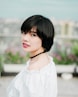 selective focus photo of woman wearing white top and black choker necklace