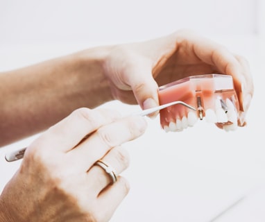 person wearing silver-colored ring while holding denture