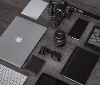 iPad near sunglasses, wallet, and DSLR camera